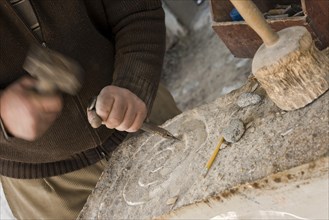 Sculptor chisels the stone