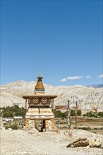 Colourfully decorated Buddhist stupa at the entrance to the village