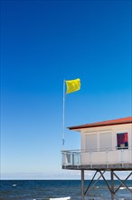 Yellow warning flag at a DLRG hut