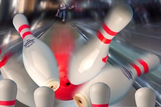 Bowling pins being hit by a red bowling ball