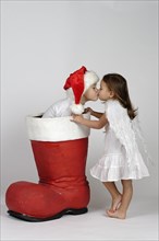 Boy in a Christmas boot and girl dressed as an angel kissing