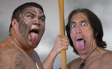 Two dancers at the ritual Haka dance with outstretched tongue