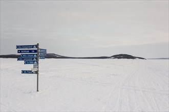 Sign post on frozen over Lake Inari