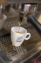 Espresso coffee pouring into a cup