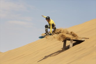 Sand boarding in the dunes of the Namib Desert