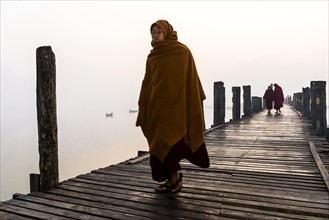 Monks walking on a teak bridge