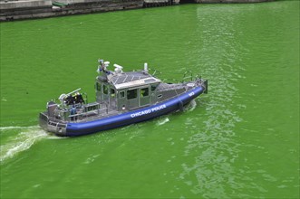 Police boat on the Chicago River green on St. Patrick's Day