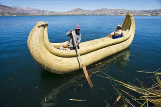 Two local in a traditional rowing boat of Totora reed on Lake Titicaca