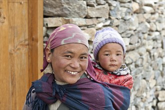 Smiling woman carrying a child on her back