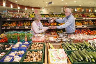 Senior couple shopping in the fruit and vegetables department of a supermarket
