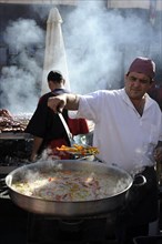 Cook boils vegetables in a large pan at the annual All Saints Market in Cocentaina