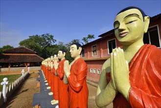 Figures of Buddhist monks in front of a monastery