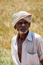 Elderly Indian man with turban near a field Uttamapalaiyam