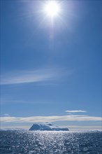 Sun shining over an iceberg