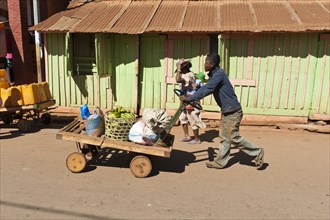 Man pushes goods on a home-made cart