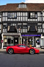 Ferrari car parked in front of a half-timbered house