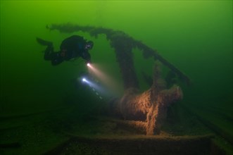 Diver inspects the pump of a shipwreck