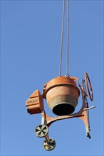 Concrete mixer hanging from a crane