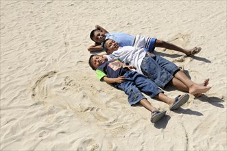 Three Kuna Indian boys lying in the sand