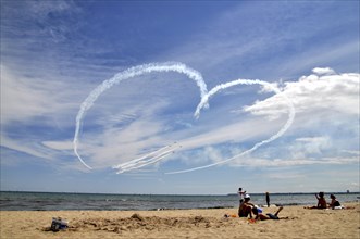 Airplanes draw heart in the sky and fighter jets fly through it