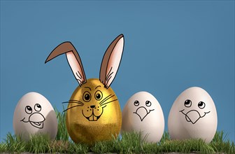 Three white eggs with painted chicken faces chicks and one golden egg with a painted rabbit face