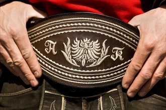 Man holding his traditional belt with both hands