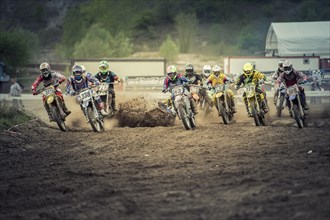 One motocross rider falling immediately after the start of a race