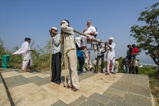 Porters carrying a Jain pilgrim up Mount Shatrunjaya