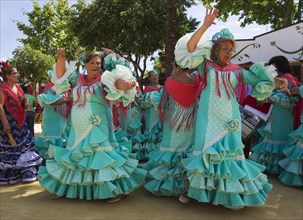 Women wearing gypsy dresses perform traditional Andalusian dances at the Feria del Caballo