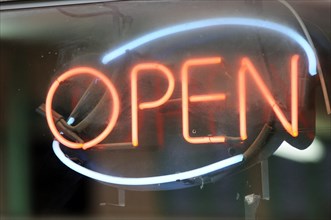 Illuminated neon sign with the word 'open'