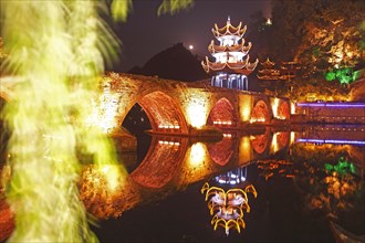 Colorfully illuminated stone bridge and the Kuixingge Pagoda at night