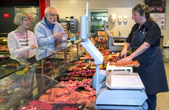 Senior couple shopping at the meat counter in the supermarket