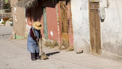 Woman sweeping outside her house