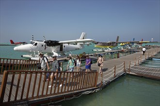 Tourists leaving the pontoon with hydroplanes moored