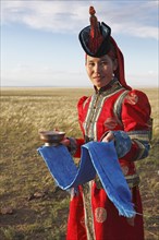 Woman in traditional dress with traditional welcome utensils