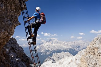 Mountain climber ascending the Via Ferrata Marino Bianchi climbing route on Cristallo di Mezzo Mountain