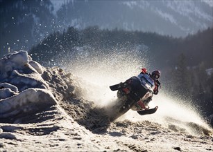 Snow mobile or ski-doo rider jumping into a curve