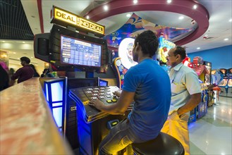 Two men playing at a gaming machine