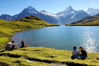 Walkers having a rest next to Bachalpsee lake near Grindelwald First