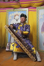 Man in the traditional costume of the Khalkha Mongols playing the Mongolian Zither