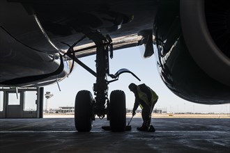 Man working on the undercarriage of an aircraft