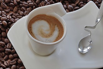 Coffee with frothed milk on coffee beans