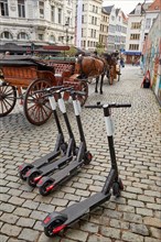 Electric scooters for rent next to a horse-drawn carriage on the Grote Markt in Antwerp