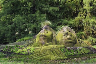 Stone statues overgrown with moss