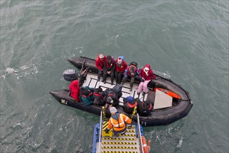 Tourists being helped out of an inflatable boat