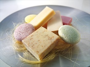 Selection of natural hand made soap bars piled on a dish