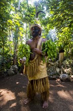 Traditional dressed man with black face in the jungle
