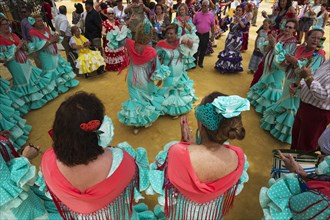 Women wearing gypsy dresses perform traditional Andalusian dances at the Feria del Caballo