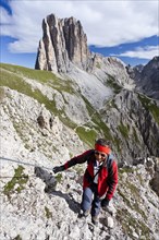 Mountain climber ascending Croda Rossa or Sextener Rotwand in the Rosengarten Group along the Via Ferrata Croda Rossa climbing route