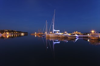 Boats reflected in the water at night